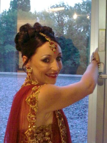 English bride in traditional Indian red and gold Asian costume with a bindi and sari
